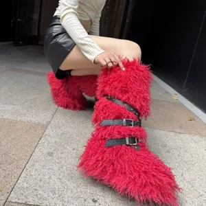 Gros plan sur des bottes punk rouges en laine de mouton avec sangles cloutées et boucles
