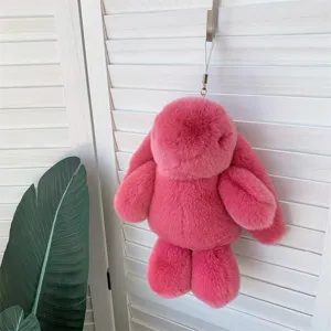 Pendentif lapin en peluche rose accroché à un volet blanc de style minimaliste chic