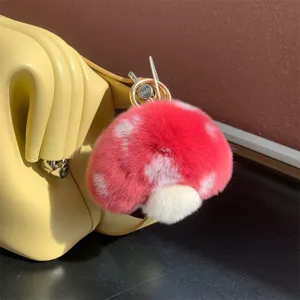 Macro detail of a soft red mushroom plush charm with white spots attached to a yellow bag