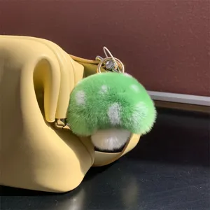 Detail view of a cute green and white plush mushroom keychain made of soft rex rabbit fur