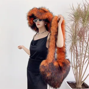 Vue détaillée d'un ensemble chapeau en fausse fourrure orange et sac cœur sur un mannequin.