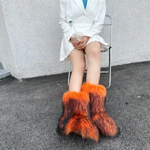 Model posing in trendy orange and black faux fur snow boots with a Y2K aesthetic