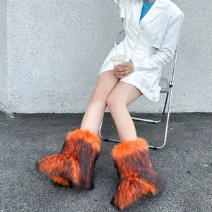 Full view of model wearing fluffy orange and black faux fur Y2K style snow boots outdoors
