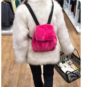 Detailansicht eines pinkfarbenen Kunstpelz-Rucksacks über einem weißen Pelzmantel