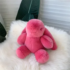 Gros plan sur la texture de la fourrure rose du lapin en peluche sur fond blanc.