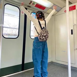Rückansicht eines Mädchens mit modischem Rucksack aus Leoparden-Kunstpelz in der U-Bahn