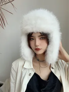Detail of a white plush faux fox fur trapper hat with earmuffs for extreme winter warmth.