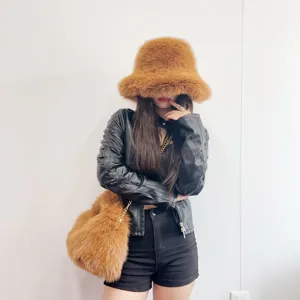Model wearing stylish faux fox fur bucket hat and matching hobo bag set in caramel