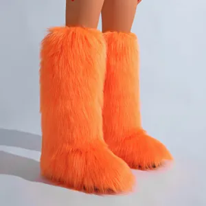 Bottes hautes en fausse fourrure orange vif avec texture pelucheuse pour l'hiver.