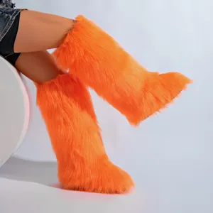 Vue détaillée de la texture des bottes de neige orange vif en fausse fourrure de renard