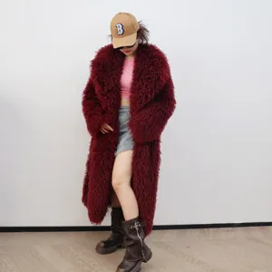 Vue détaillée de la texture d'un long manteau bordeaux en fausse fourrure avec un col