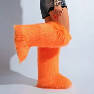 Gros plan de bottes orange vif en fausse fourrure à texture moelleuse pour un look d'hiver stylé