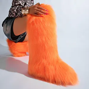 Gros plan détaillé de bottes de neige orange vif en fausse fourrure de renard très douces