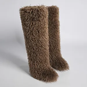 Detalle de botas mosqueteras de 72 cm de piel sintética marrón peluda para moda de invierno.