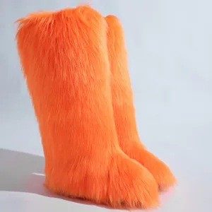 Vue détaillée de bottes de neige orange en fausse fourrure à texture douce et hirsute