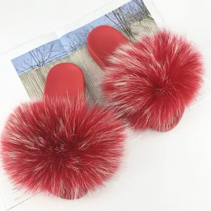 Vista ravvicinata di lussuose pantofole rosse in pelliccia di procione e PVC.