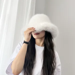 Chapeau cloche en fausse fourrure blanche porté par un mannequin dans un décor minimaliste.