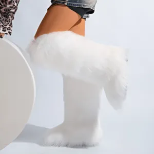 Gros plan de bottes de neige blanches en fausse fourrure portées par un mannequin