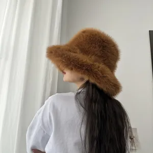 Vue latérale d'un chapeau bob duveteux en fausse fourrure de renard marron en intérieur.