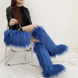 Bottes hautes en fausse fourrure bleue et sac à main assorti style punk portés par modèle