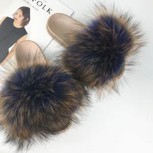 Stylish golden PVC sole slides with fluffy raccoon fur pom-poms for summer fashion wear