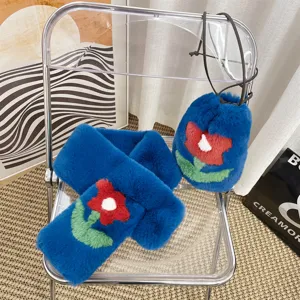 Close-up of blue faux rabbit fur scarf and drawstring bag with red flower pattern