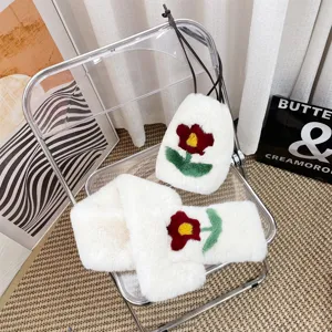 White faux fur bag and scarf set with red flower applique shown on a clear chair