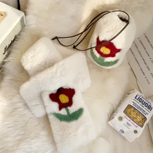 Detailed view of plush drawstring bag and matching scarf set with red flower motif