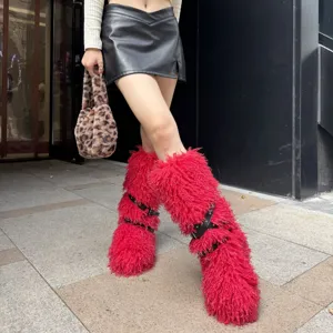 Vue détaillée montrant la texture des bottes en fausse fourrure rouge et sangles cloutées