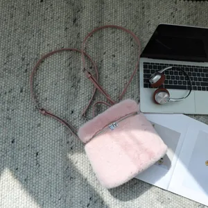 Flachbild eines rosa Plüschrucksacks aus Kunstpelz auf einem Teppich neben einem Laptop