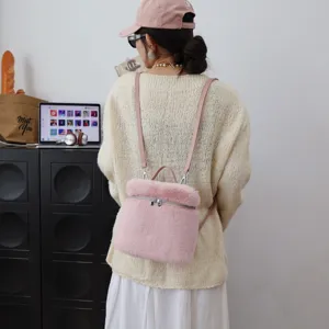 Detailansicht des rosa Kunstpelz-Minirucksacks, getragen von einem Modell im Innenbereich