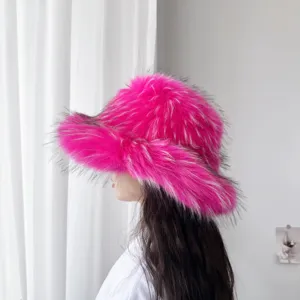 Modell mit einem leuchtend rosa Fischerhut aus Fuchspelzimitat mit breiter Krempe für den Winter