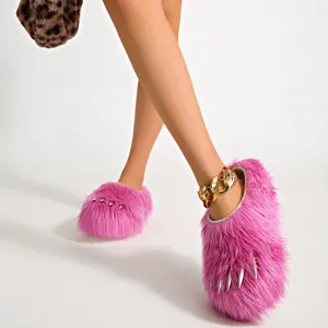 Close-up of pink faux fur claw slippers with silver studs and thick platform sole