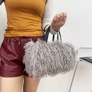 Dettaglio della borsa tote grigia in finta pelliccia riccia con manici neri su una modella