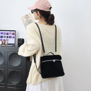 Detailansicht eines schwarzen Plüsch-Rucksacks aus Kunstpelz, getragen von einem Model.