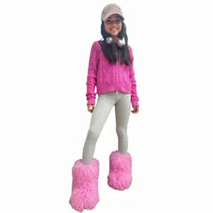 Fille portant des bottes de neige roses en fausse fourrure et un pull en tricot.