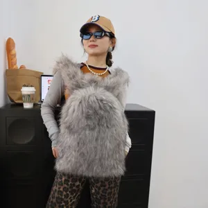 Close-up of grey plush faux fur backpack on model for trendy Y2K winter fashion style.