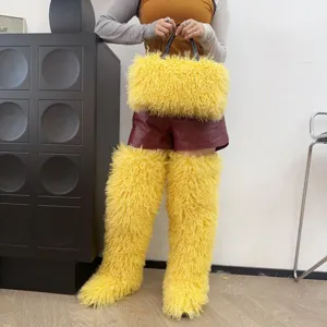 Dettaglio della borsa tote in ecopelliccia gialla con stivali di peluche abbinati