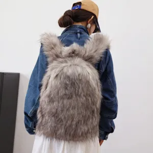 Back view of a stylish faux fur bunny-shaped backpack worn by a model in denim.
