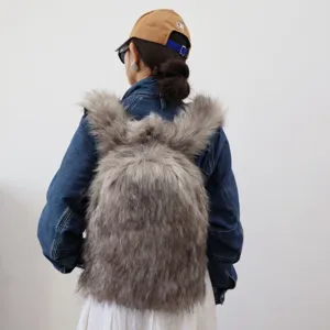 Detailed back view of a grey faux raccoon fur Y2K backpack styled with a denim jacket