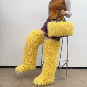 Modella che mostra una borsa tote in ecopelliccia gialla con stivali coordinati