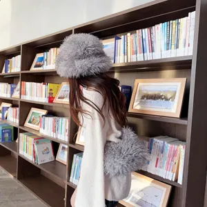 Side view of grey faux Mongolian lamb fur bucket hat and matching plush cross-body bag