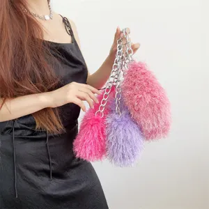 Detailed shot of multi-color plush faux fur handbags with silver chain strap on model