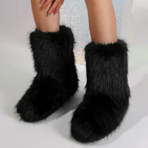 Bottes de neige noires en fausse fourrure style Y2K portées par un mannequin de mode