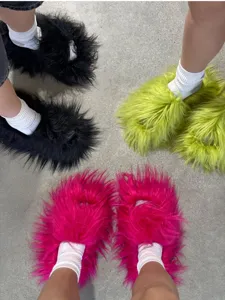Pantoufles Y2K en fausse fourrure vibrantes noires, vert fluo et rose vif en extérieur.