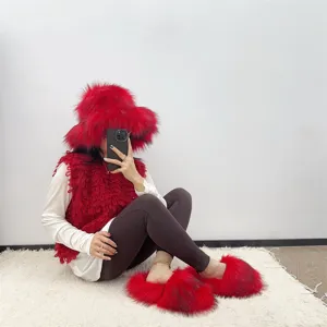 Vibrant red faux fur hat and matching slipper set styled in a cozy indoor setting