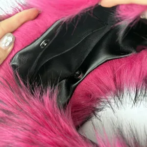 Close-up of interior black lining and magnetic snap of pink faux fur handbag.