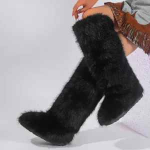 Detail view of black knee-high faux fox fur snow boots with thick plush texture.
