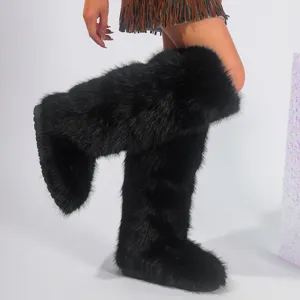 Close-up detail of fluffy black faux fox fur knee-high snow boots showcasing the Y2K style fit