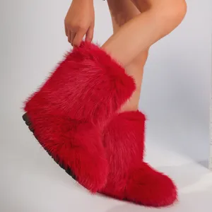 Gros plan de bottes de neige en fausse fourrure rouge vif style Y2K, texture moelleuse.